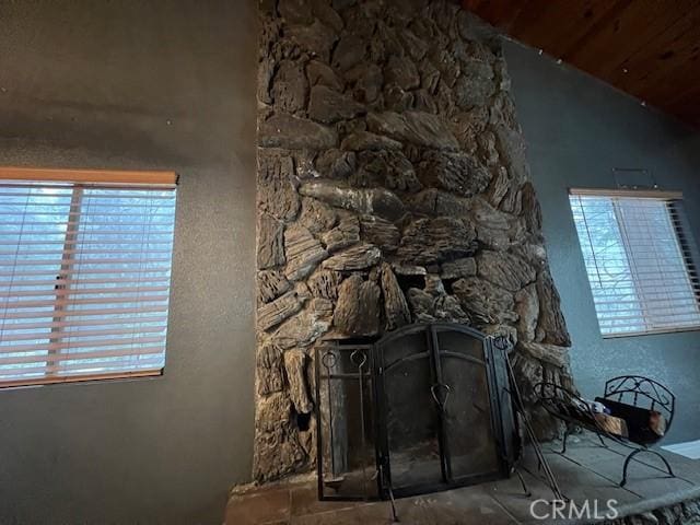 details with wood ceiling and a stone fireplace