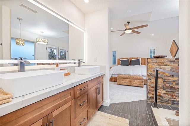 bathroom featuring ceiling fan, vanity, and vaulted ceiling