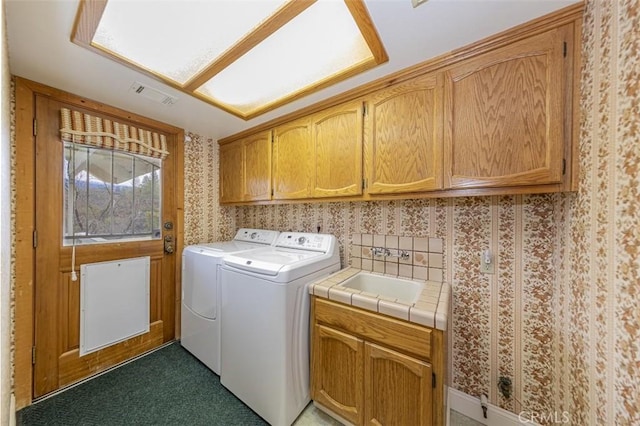 laundry area with washer and dryer, sink, and cabinets