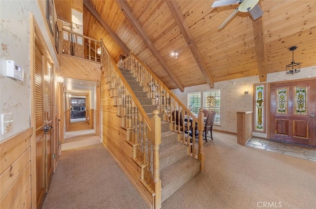 carpeted foyer with wood ceiling, high vaulted ceiling, wooden walls, and beam ceiling