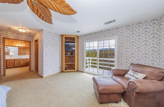 living room featuring sink and light colored carpet