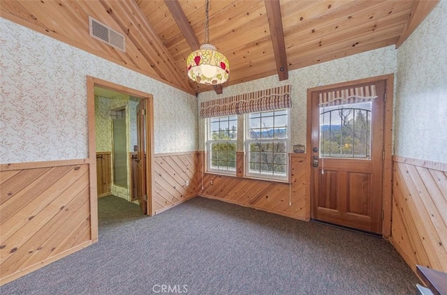 unfurnished room with vaulted ceiling with beams, dark colored carpet, wood ceiling, and wooden walls