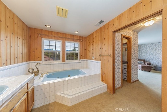 bathroom featuring vanity and tiled bath