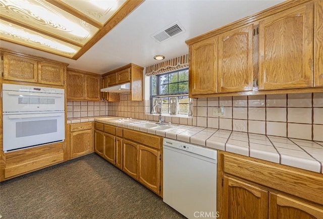 kitchen featuring sink, tile countertops, white appliances, and decorative backsplash