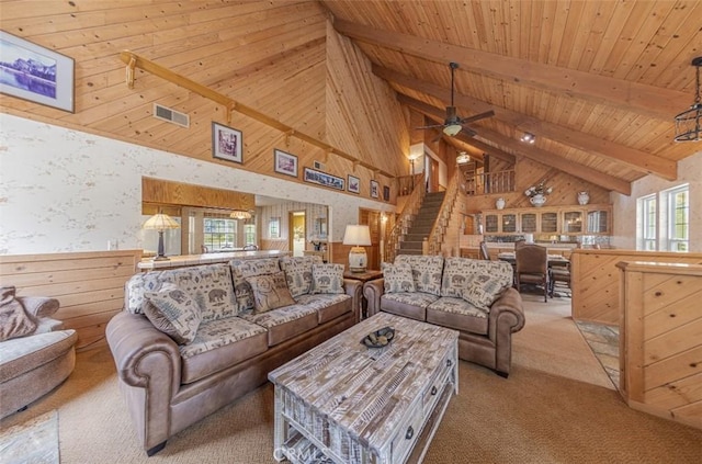 carpeted living room featuring wood walls, ceiling fan, high vaulted ceiling, wood ceiling, and beam ceiling