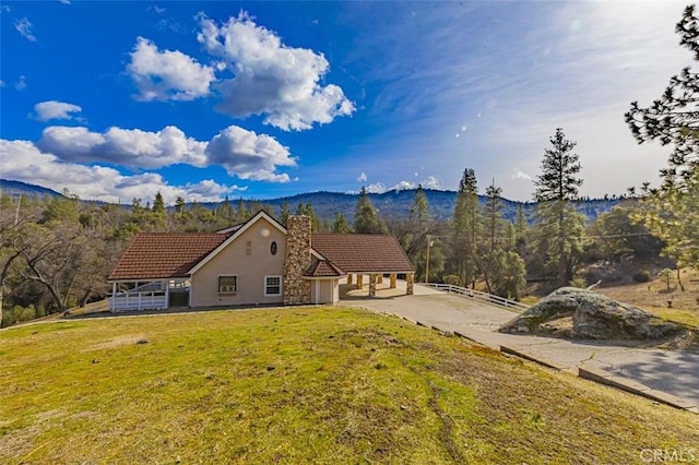 view of front of house featuring a mountain view and a front yard