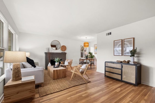 living room with hardwood / wood-style flooring and a brick fireplace