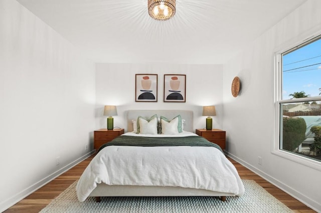 bedroom with hardwood / wood-style flooring and a chandelier