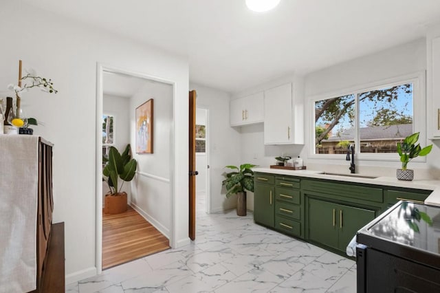 kitchen featuring green cabinetry, black electric range oven, sink, and white cabinets