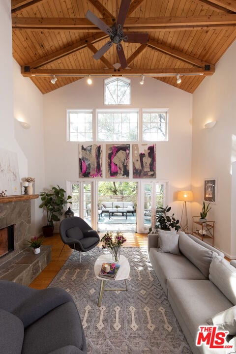 living room with beam ceiling, a fireplace, wooden ceiling, and wood-type flooring