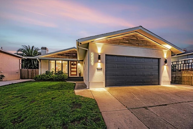 view of front of house featuring a garage and a lawn