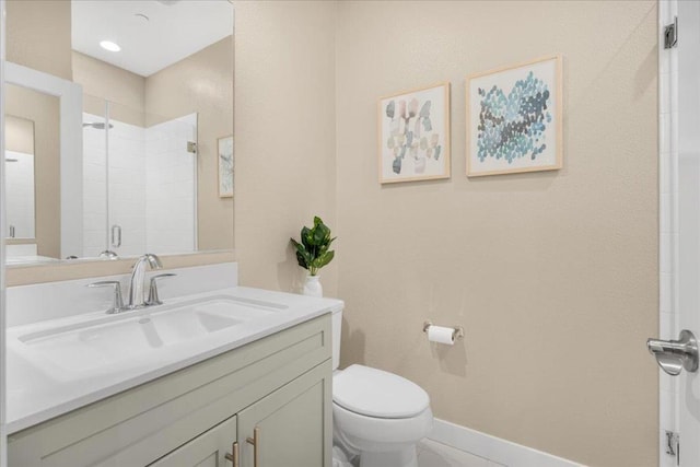 bathroom with toilet, vanity, and a shower with shower door