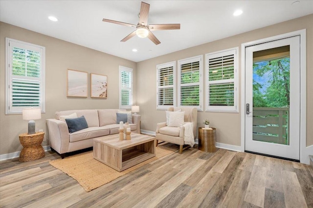 living room featuring ceiling fan and light hardwood / wood-style floors