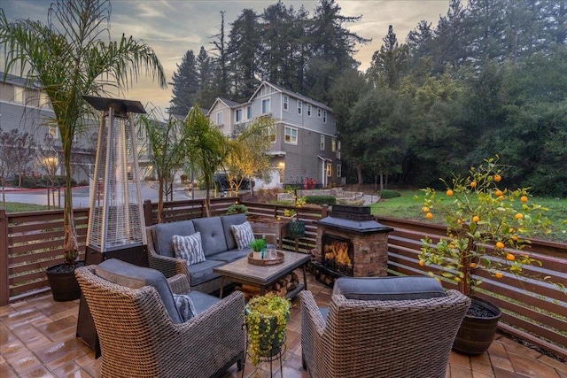 patio terrace at dusk featuring an outdoor living space with a fireplace