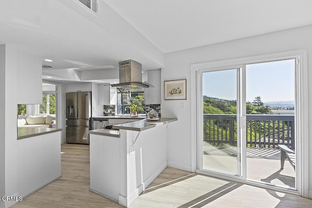 542 San Clemente Way, Camarillo, CA 93010 - kitchen with stainless steel appliances, island exhaust hood, a peninsula, and light wood-style flooring