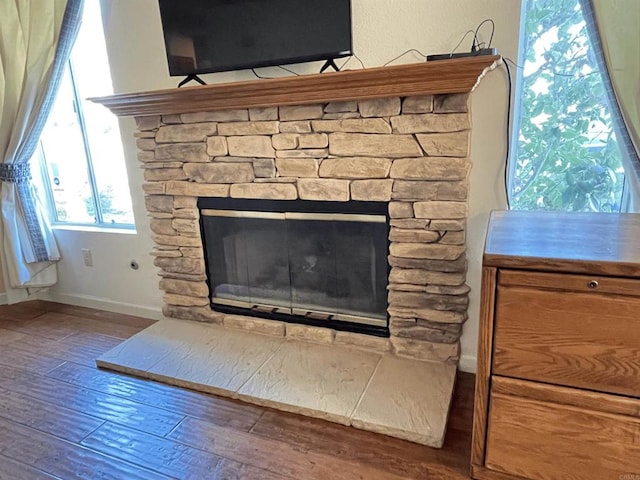 interior details featuring a stone fireplace and hardwood / wood-style floors