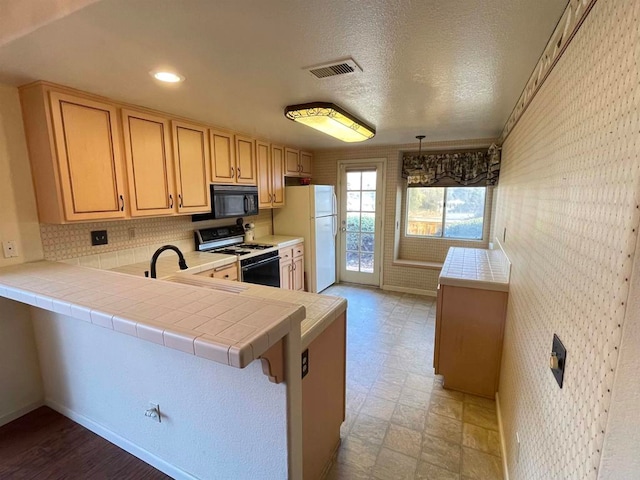 kitchen featuring sink, tile countertops, white appliances, and kitchen peninsula