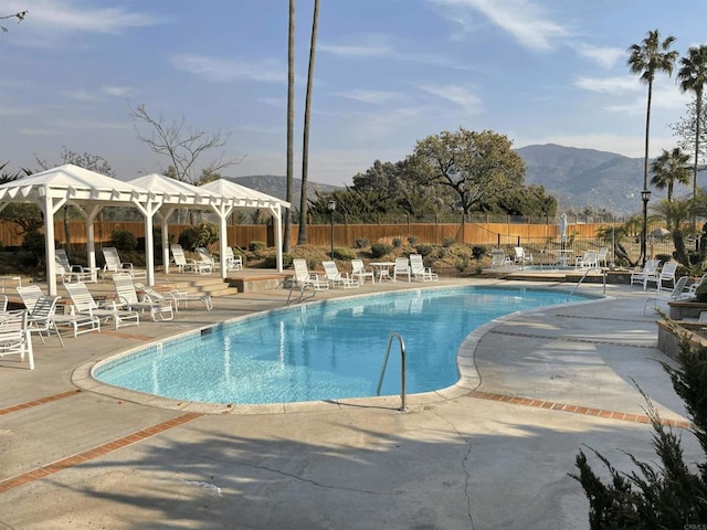 view of pool featuring a gazebo, a mountain view, and a patio area