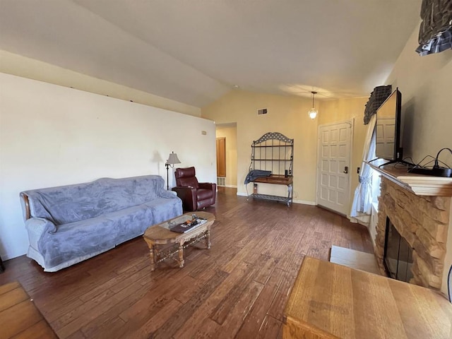 living room featuring lofted ceiling, dark wood-type flooring, and a fireplace