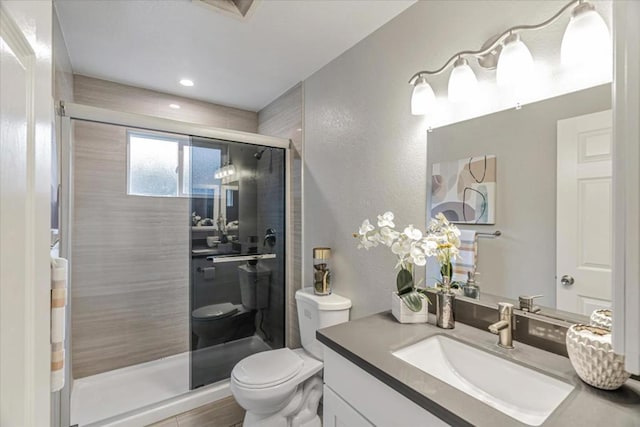 bathroom with vanity, toilet, and a shower with shower door