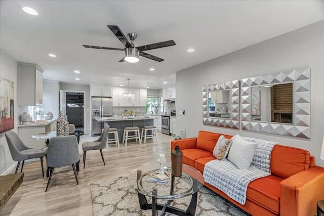 living room featuring ceiling fan and light wood-type flooring