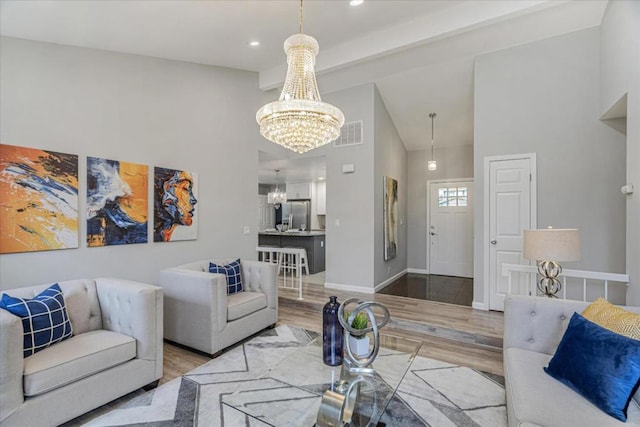 living room with beamed ceiling, high vaulted ceiling, hardwood / wood-style floors, and an inviting chandelier