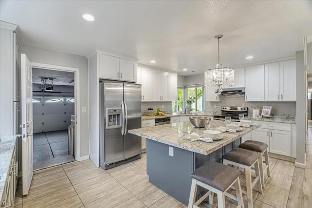 kitchen featuring white cabinetry, stainless steel appliances, and light stone countertops