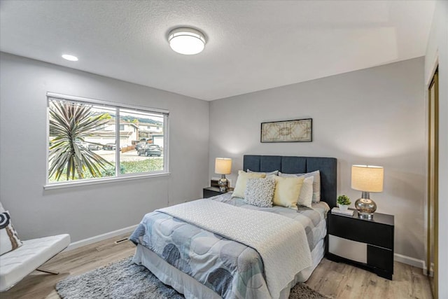 bedroom featuring a textured ceiling and light wood-type flooring