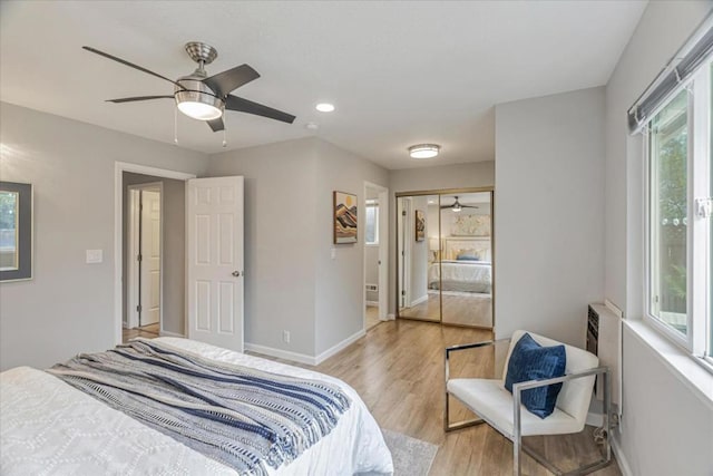 bedroom featuring light hardwood / wood-style floors, a closet, and ceiling fan