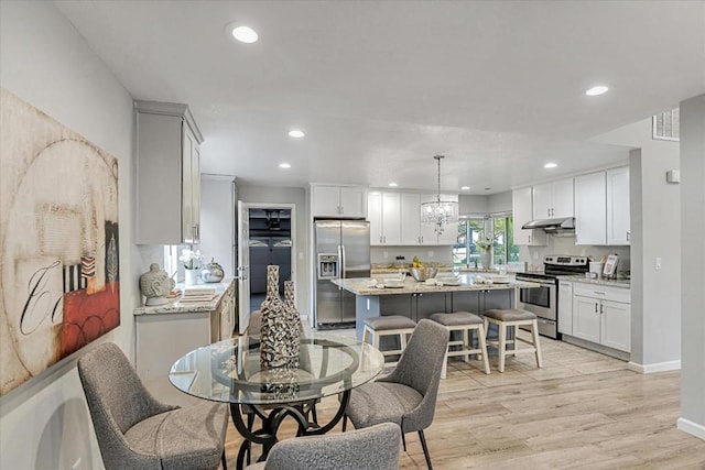 dining area featuring light hardwood / wood-style flooring and a chandelier