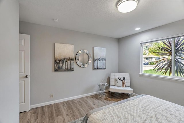 bedroom featuring a textured ceiling and light wood-type flooring