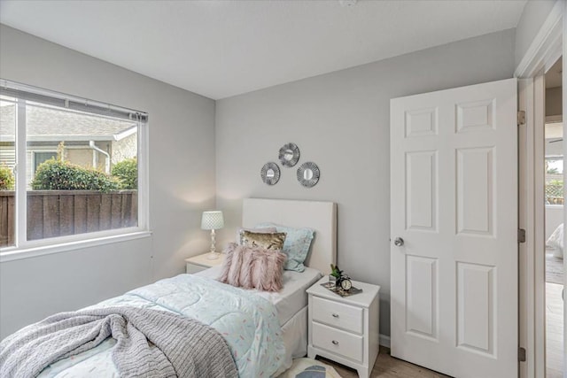 bedroom with multiple windows and light hardwood / wood-style floors