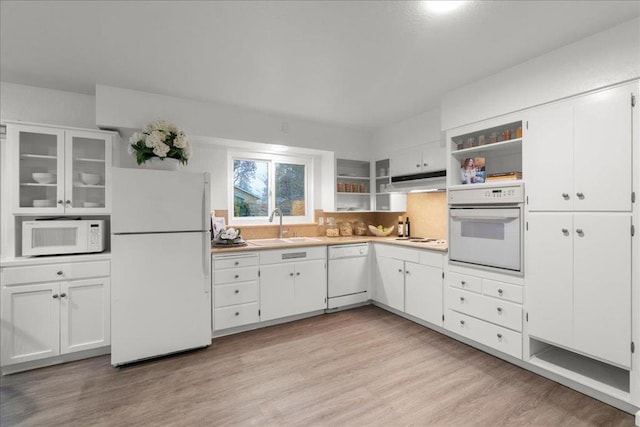 kitchen with white appliances, sink, light hardwood / wood-style flooring, and white cabinets