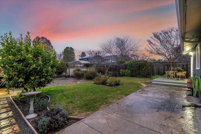 yard at dusk featuring a patio