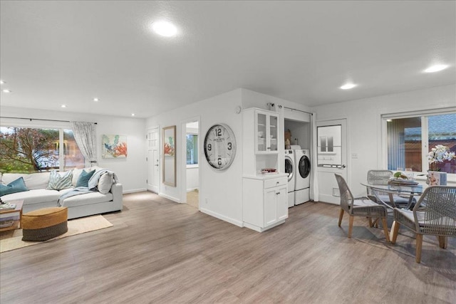 living room with separate washer and dryer and light hardwood / wood-style flooring