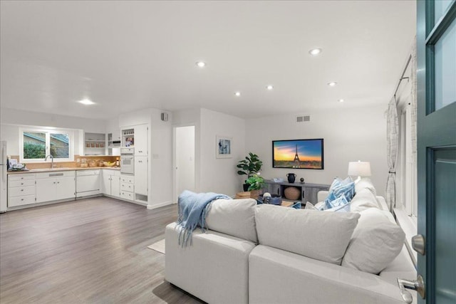 living room with sink and light wood-type flooring