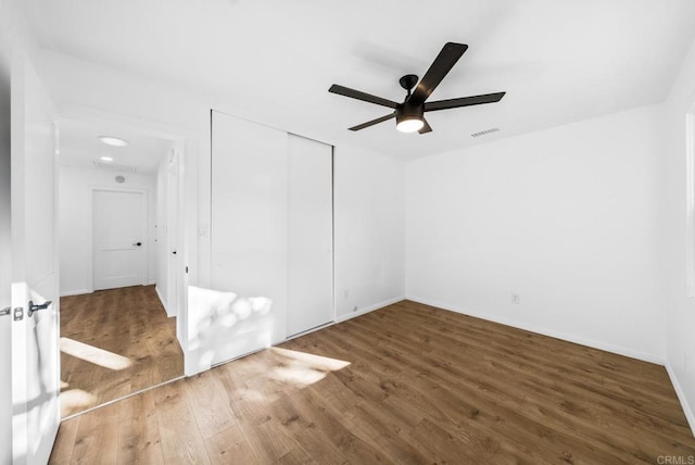 empty room featuring dark wood-type flooring and ceiling fan