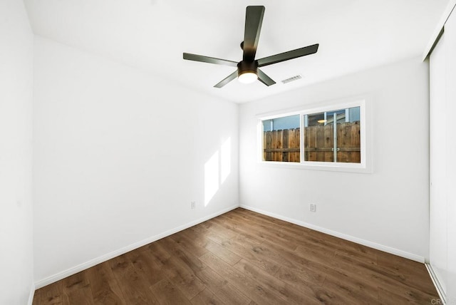 empty room featuring ceiling fan and dark hardwood / wood-style floors