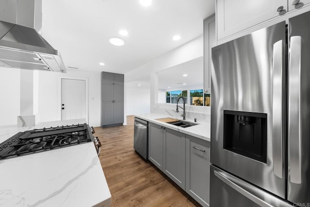 kitchen with stainless steel appliances, extractor fan, sink, and gray cabinetry