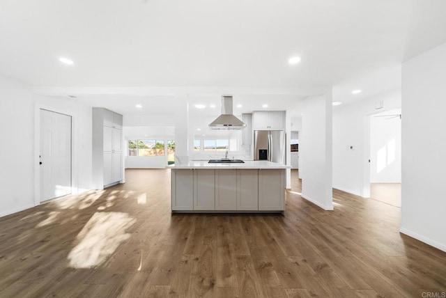 kitchen with stainless steel refrigerator with ice dispenser, island exhaust hood, dark hardwood / wood-style flooring, and gray cabinets