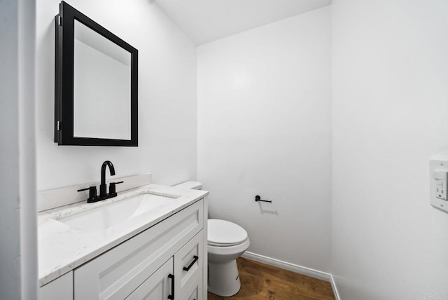 bathroom with vanity, hardwood / wood-style flooring, and toilet