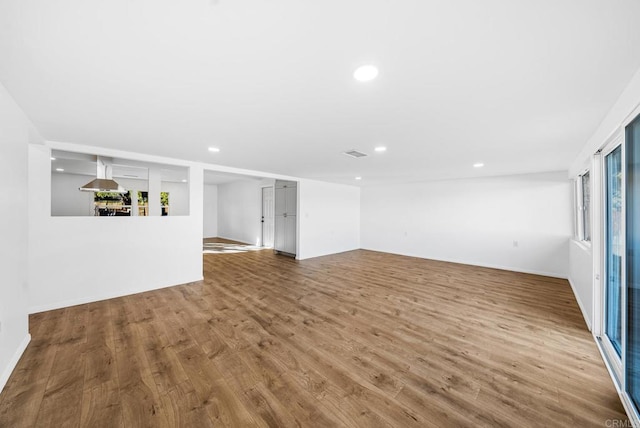 unfurnished living room featuring hardwood / wood-style flooring and a wealth of natural light