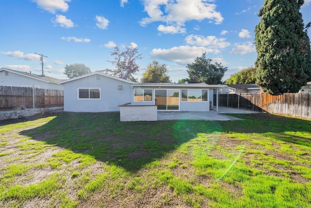 rear view of property featuring a yard and a patio