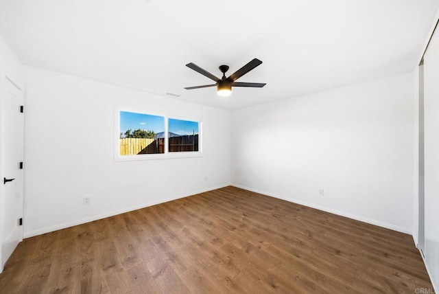 empty room with ceiling fan and hardwood / wood-style floors