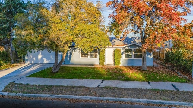 view of property hidden behind natural elements featuring a front yard