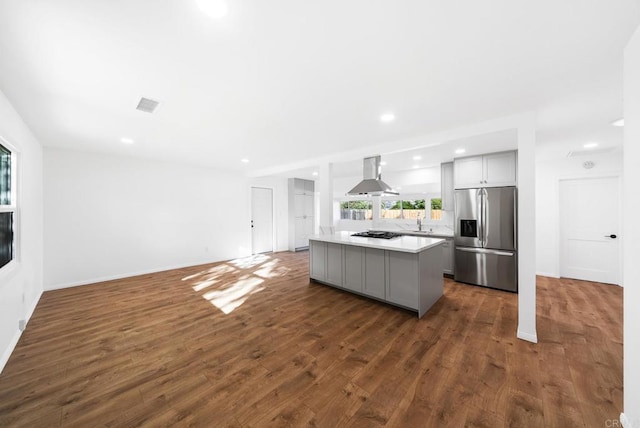 kitchen with gray cabinetry, island range hood, stainless steel fridge, and a center island