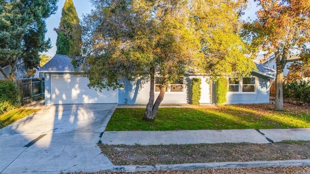 obstructed view of property featuring a garage and a front lawn