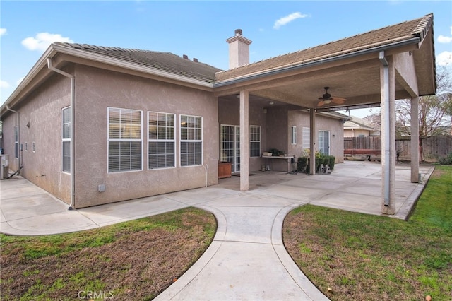 back of house featuring a lawn, cooling unit, ceiling fan, and a patio area