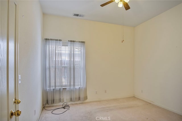 spare room featuring light colored carpet and ceiling fan