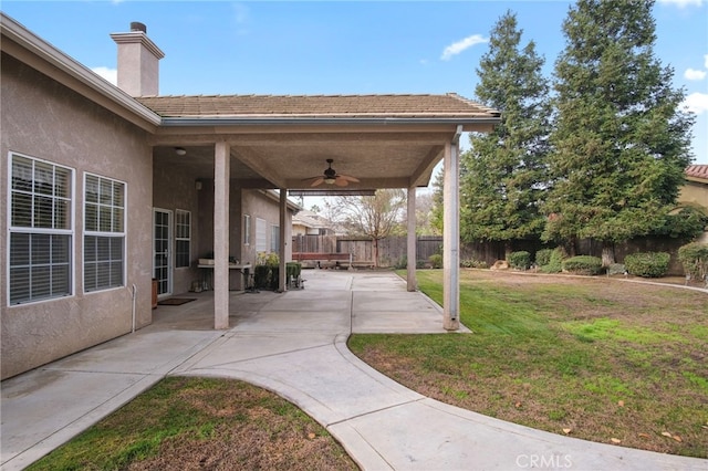 view of yard with ceiling fan and a patio